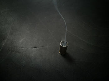 High angle view of smoke emitting from metal container on table