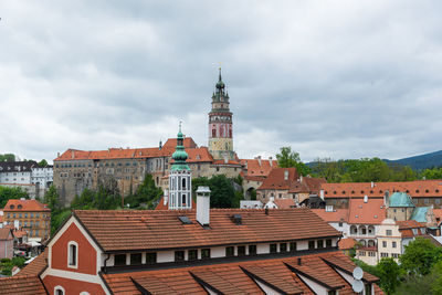 Buildings in city against cloudy sky