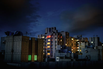 Illuminated buildings against sky at night