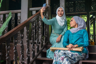 Full length of mother and daughter on railing