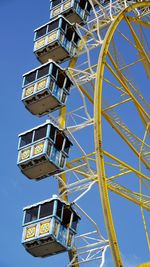 Low angle view of ferris wheel against clear blue sky