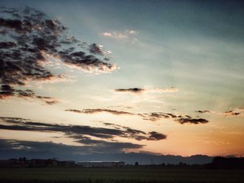 Scenic view of silhouette field against sky during sunset