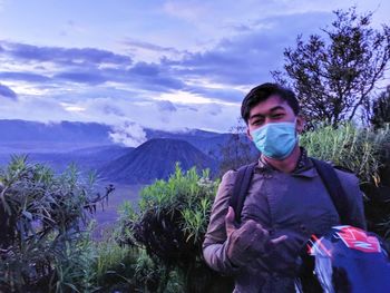 Portrait of young man against mountains against sky