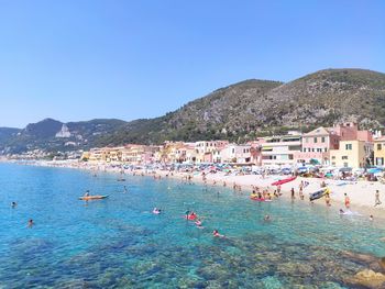 People on beach against clear sky