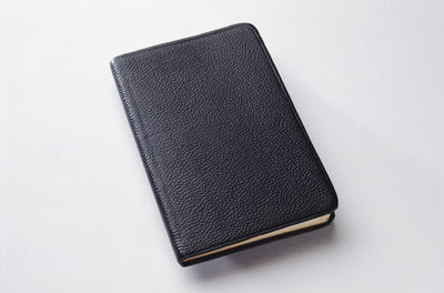 High angle view of open book on table against white background