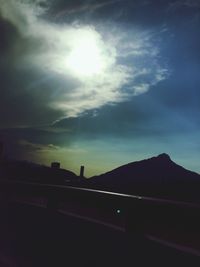 Silhouette of mountain against cloudy sky