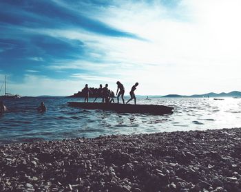 People on beach against sky