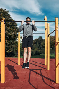 Full length of man standing on column against sky