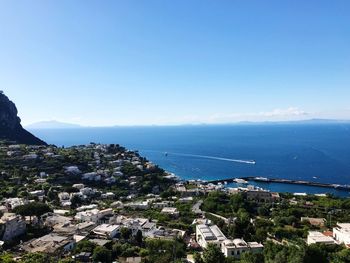 High angle view of townscape by sea against clear sky