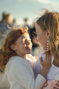 Happy mother having fun with daughter on sunny day