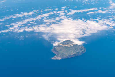 Aerial view of volcano amidst sea