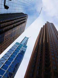 Low angle view of skyscrapers against cloudy sky