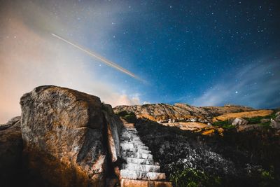 Low angle view of rock formation against sky at night