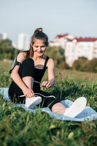 Full length of woman sitting on field