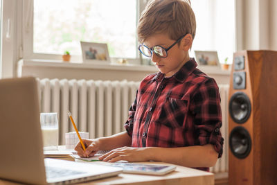 Boy sitting on table at home