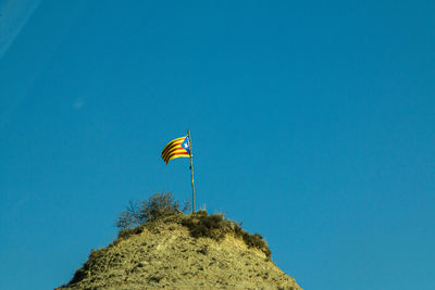 Low angle view of kite flying against blue sky