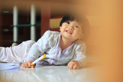 Portrait of cute boy holding table at home