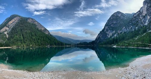 Scenic view of lake by mountains against sky