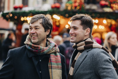 Happy mature man with son at christmas market