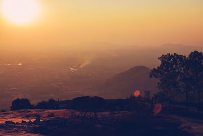 Scenic view of silhouette mountains against orange sky