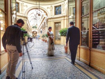 Rear view of people photographing in city