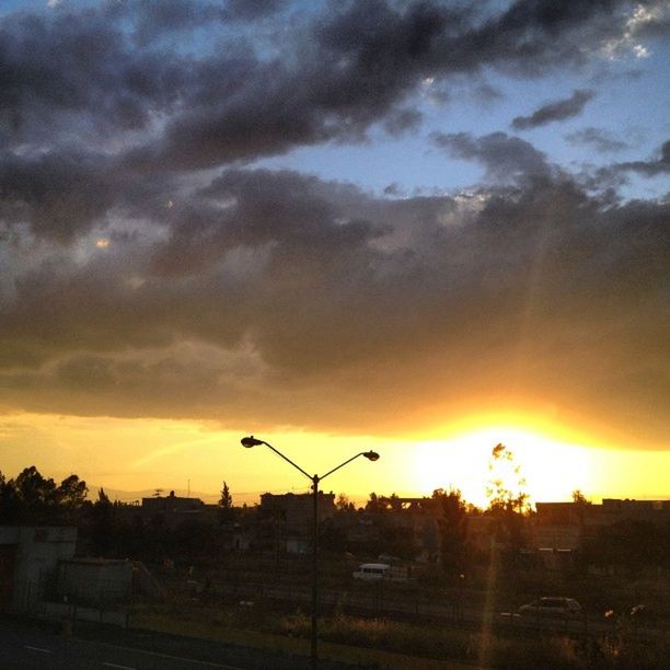 sunset, orange color, sun, sky, silhouette, cloud - sky, scenics, beauty in nature, dramatic sky, building exterior, landscape, built structure, nature, architecture, sunlight, idyllic, sunbeam, tranquil scene, cloud, tranquility