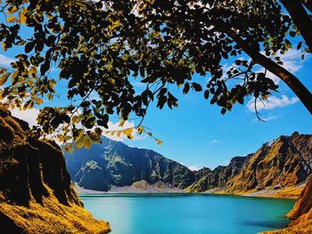 Scenic view of lake and mountains against blue sky