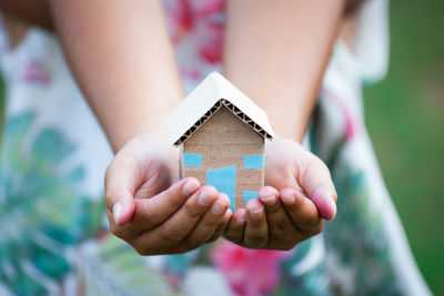 Close-up of woman holding hand against blurred background