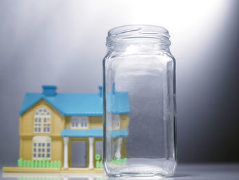 Close-up of empty jar with model home on table