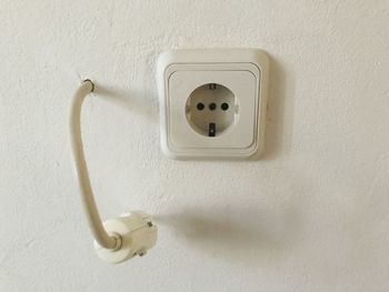 Close-up of electric lamp on wall at home