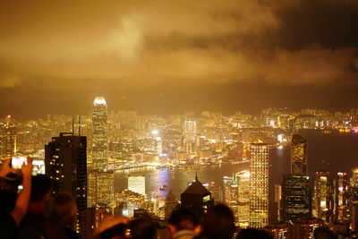 Crowd in city against sky at night