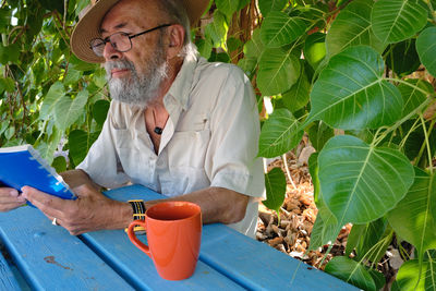 Portrait of senior man holding plant