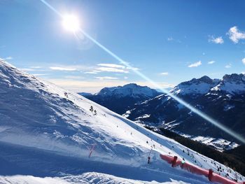 Scenic view of snowcapped mountains against sky on sunny day