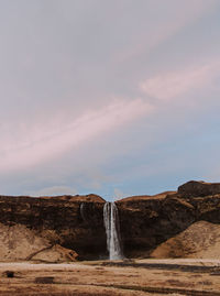 Scenic view of waterfall against sky