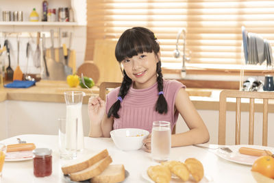 Portrait of smiling girl with drink on table