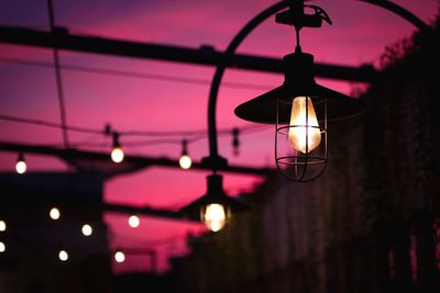 Low angle view of illuminated pendant light hanging during night