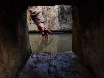 Man holding umbrella against wall