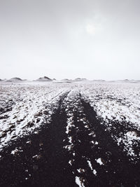 Scenic view of snow covered land against clear sky