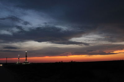 Scenic view of silhouette field against sky during sunset