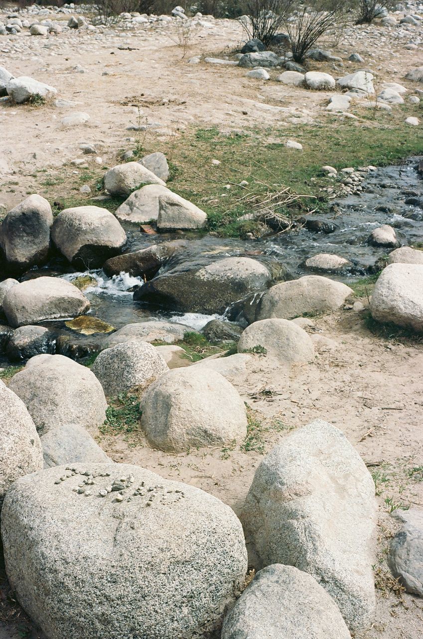 HIGH ANGLE VIEW OF STONES ON BEACH