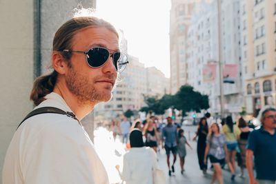 Portrait of man standing against building in city