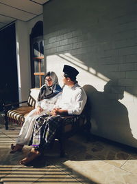 Young couple enjoying warm morning sun in front of their home