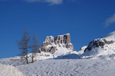 Scenic view of snowcapped mountains against blue sky