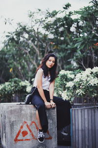 Portrait of young woman against plants