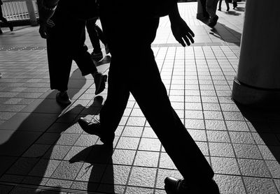 Low section of people walking on sidewalk