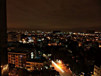Illuminated cityscape against sky at night