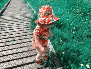 High angle view of baby girl standing on grass