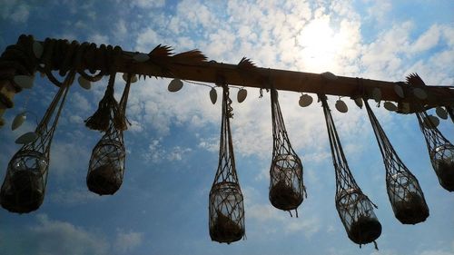 Low angle view of clothes hanging on rope against sky