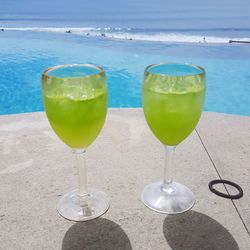 Glasses of drink on table at beach