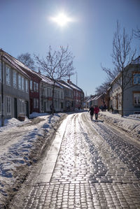 Man walking on snow covered road in city